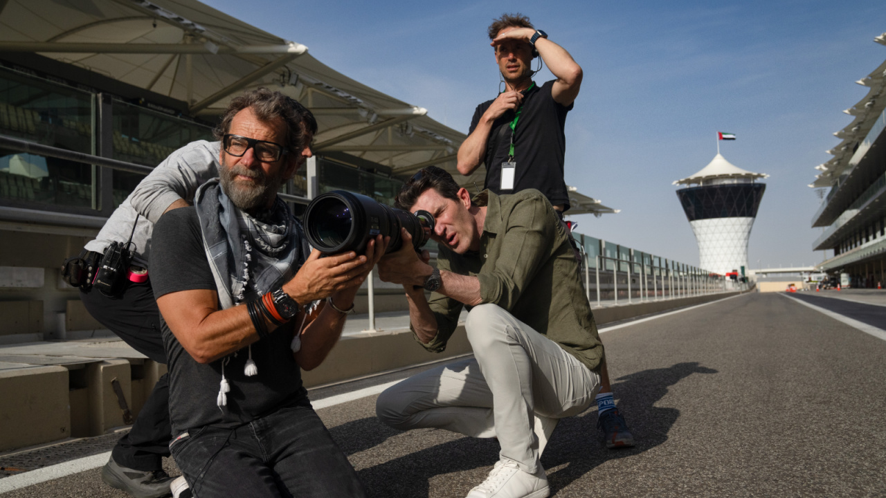 Director/Producer Joseph Kosinski (eye to viewfinder) on the set of Apple Original Films’ 'F1', a Warner Bros. Pictures release. Photo Credit: Photo by Scott Garfield. Courtesy Warner Bros Pictures / Apple Original Films. Copyright: © 2025 Warner Bros. Entertainment Inc. All Rights Reserved.