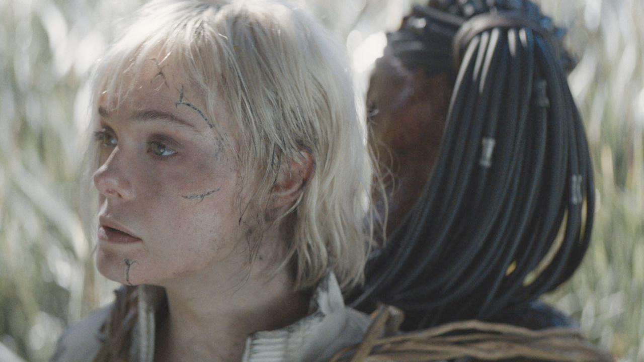 (L to R) Elle Fanning as Thia and Dimitrius Schuster-Koloamatangi as Dek in 20th Century Studios' 'Predator: Badlands' film. Photo courtesy of 20th Century Studios. © 2025 20th Century Studios. All Rights Reserved.